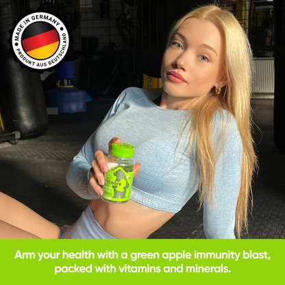 Frau hält Probears Immune System Gummibärchen, betont Gesundheitsförderung mit einem grünen Apfel-Geschmack, reich an Vitaminen und Mineralien.